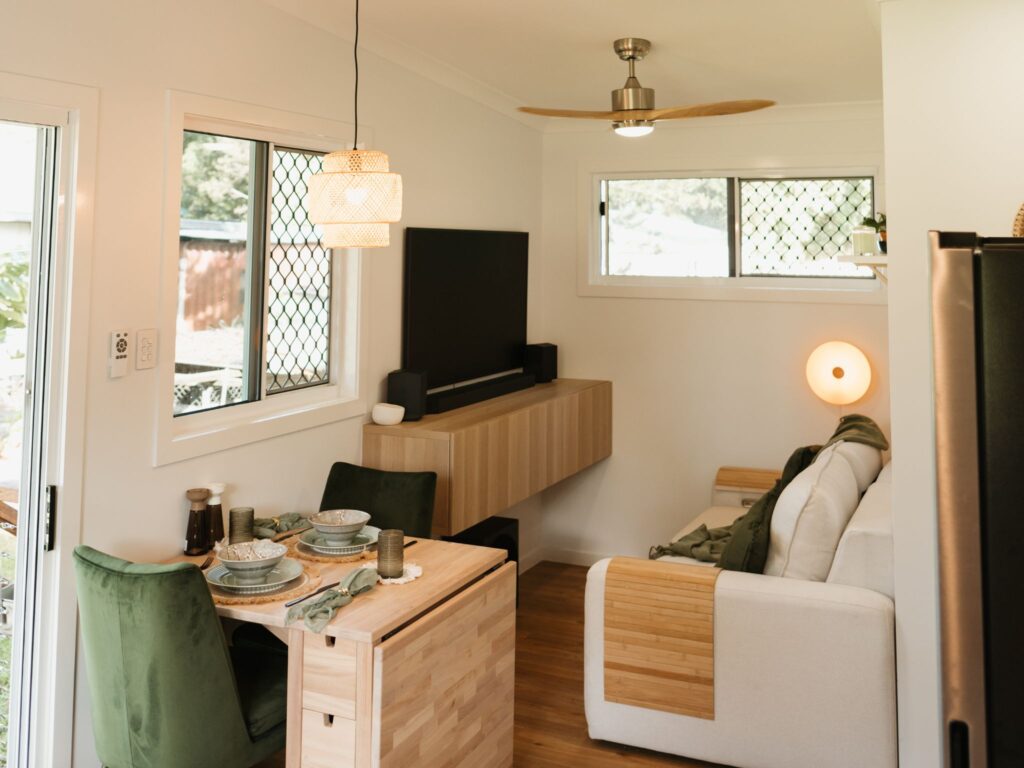 Cosy living room setup inside a backyard office pod featuring a sofa, coffee table, and stylish decor.